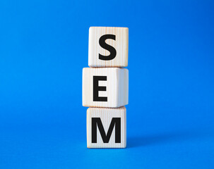 SEM - Search Engine Marketing symbol. Wooden cubes with words SEM. Beautiful blue background. Business and SEM concept. Copy space.
