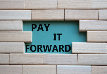 Pay it forward symbol. Concept words Pay it forward on wooden blocks. Beautiful grey green...