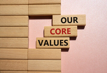 Our core values symbol. Concept words Our core values on wooden blocks. Beautiful pink background....