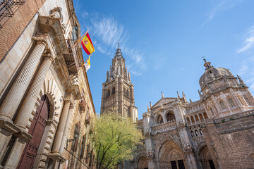 Fototapeta na wymiar Toledo Cathedral Facade and Flag of Spain - Toledo, Spain