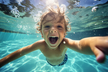 Happy kid swimming underwater and having fun. Happy childhood and summer vacation. High quality photo