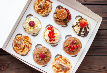 Vanilla, chocolate and peanut butter cupcakes with salted caramel, fresh raspberry, strawbeery and red currant in gift paper box