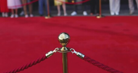 Red carpet with ropes and golden barriers on a luxury party entrance, cinema premiere film festival event award gala ceremony, wealthy rich guests arriving, outdoor decoration elements, summer day