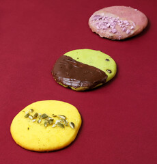 Cookies with lemon flavor and pumpkin seeds, lavender flavor and pistachio-chocolate icing. Close-up