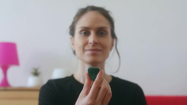 Female hands stretching green Malachite close up.Portrait female yoga instructor does an esoteric practice with crystals. Malachite is a copper carbonate hydroxide mineral. Meditation with precious