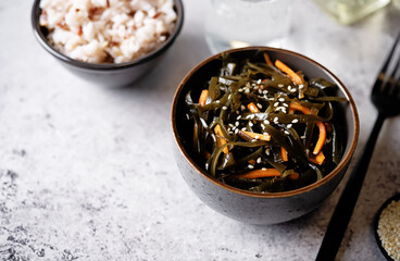 Seaweed with carrot and sesame seeds in a bowl