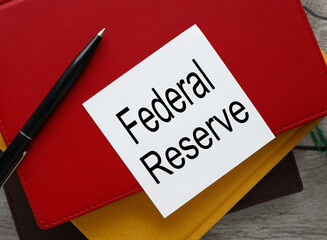 The Federal Reserve view from above. workspace with text on a white sticker on a red notepad.