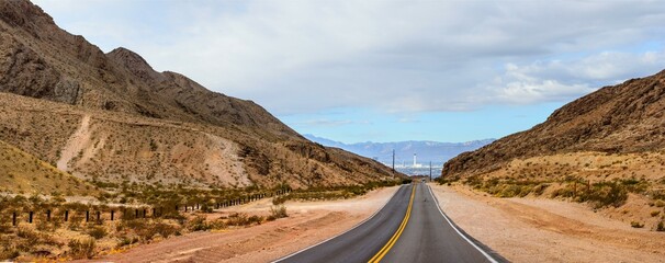 Desert Serenity: Panoramic View of an Empty Road Surrounded by Red Rock Canyon After a Storm, Presented in Captivating 4K Resolution