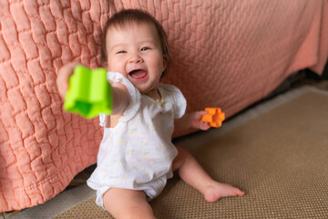 lifestyle home portrait of adorable and beautiful Asian Caucasian mixed baby girl playing on the...