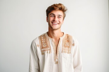 Handsome young man in traditional clothes smiling and looking at camera.