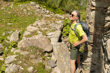 An adult tourist stands at the ruined walls in the Alps, Austria