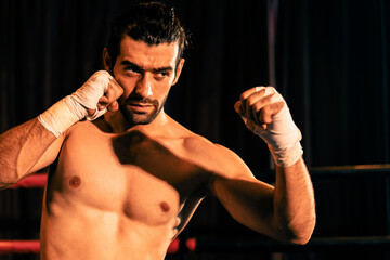 Boxing fighter shirtless posing, caucasian boxer punch his bare fist and wrap in front of camera,...