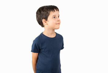 Child wearing casual t-shirt standing over white background looking away to side with smile on...