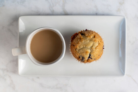 blueberry miffin served with a cup of coffee
