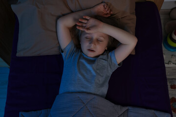 Little boy snoring while sleeping in bed at night, top view © New Africa