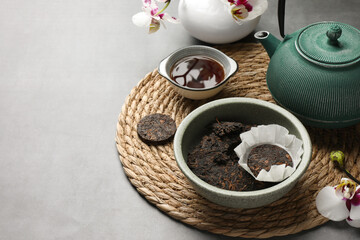 Composition with aromatic pu-erh tea on light grey table. Space for text