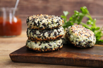 Delicious vegan cutlets with sesame on wooden table, closeup