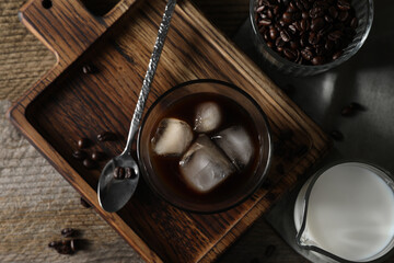 Delicious iced coffee, milk and beans on wooden table, flat lay