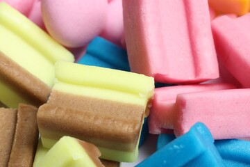 Different tasty colorful bubble gums as background, closeup