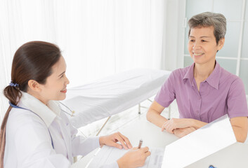 Fototapeta premium asian patient talk with doctor in mental health clinic, she screening and write patient information on patient chart, elderly healthcare promotion