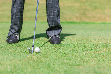 ゴルフ場でゴルフをするゴルファーの男性の足元
