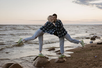 Young couple in love on the beach at sunset. Lifestyle people concept.