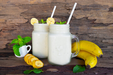 Banana fresh cocktail vanilla smoothies  fruit juice beverage healthy the taste yummy in glass drink episode good morning on wooden background from the top view.