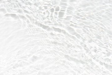White water with ripples on the surface. Defocus blurred transparent white colored clear calm water surface texture with splashes and bubbles. Water waves with shining pattern texture background.