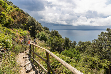 Fototapeta na wymiar Unrecognized hikers trekking along the scenic Vernazza Monterosso trail in the popular 5 villages Cinque Terre trail in Italy