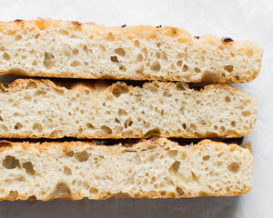 Cross section of focaccia on a white background, fresh homemade focaccia bread