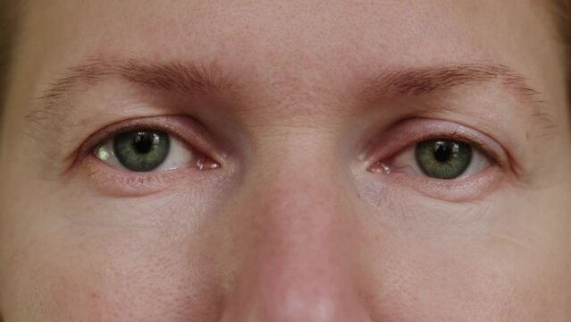 Collage of human eyes and faces, close-up. Different ages and genders people opening eyes and looking at camera.