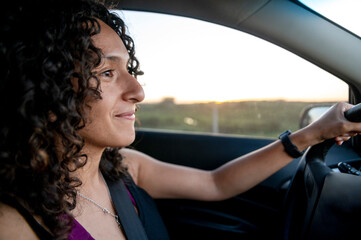 Fototapeta na wymiar Happy woman smiling while driving a car on the road.