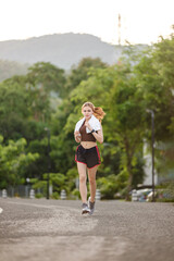 Healthy Asian woman is jogging running outdoor. Sport girl running. Female exercising at outdoor park. Sunset or Sunrise.