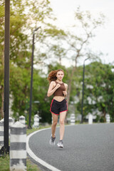 Healthy Asian woman is jogging running outdoor. Sport girl running. Female exercising at outdoor park. Sunset or Sunrise.