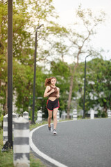 Healthy Asian woman is jogging running outdoor. Sport girl running. Female exercising at outdoor park. Sunset or Sunrise.