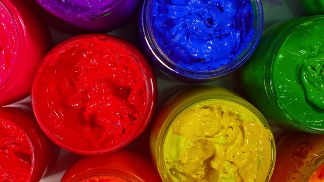 .top view scenery Bright colors for printing fabrics packed in glass jars spinning around..colorful of ink for print tee shirt in tee shirt factory..colorful ink background..