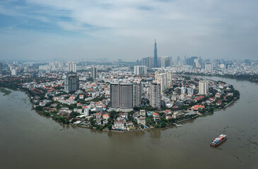 Classic aerial view of Ho Chi Minh City on a sunny day from Thao Dien with container boats working on Saigon River. Landmark building and city skyline can be seen in background.
