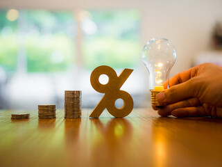 Percentage model and coins stack with light bulb . Idea and management of the banking system,...