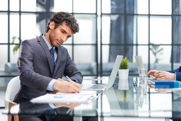 Young modern business man working using computer while sitting in the office.