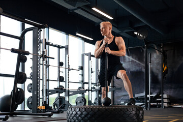 Fototapeta na wymiar Sport training for endurance, strong man with hammer. Concept of crossfit workouts.