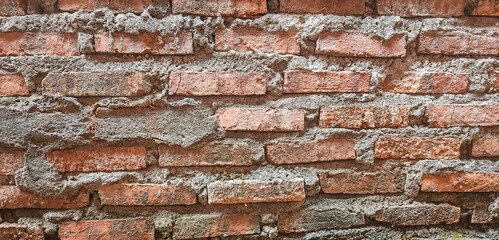 brick wall of red color, Old, beginning to collapse, carelessly laid brickwork, Background. Vintage...