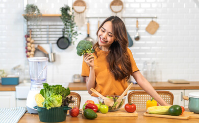 Portrait of beauty body slim healthy asian woman having fun cooking and preparing cooking vegan food healthy eat with fresh vegetable salad on counter in kitchen at home.Diet.Fitness, healthy food