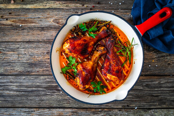 Pan fried chicken drumsticks on wooden background