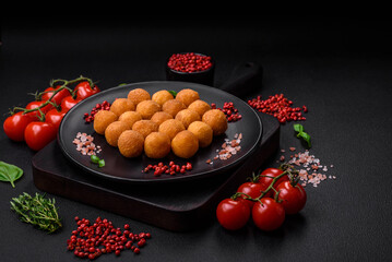 Delicious fried potato balls with breaded mozzarella, salt, spices and herbs