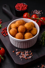 Delicious fried potato balls with breaded mozzarella, salt, spices and herbs