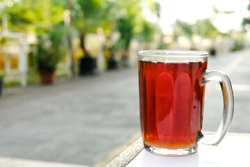 glass of hot tea on wooden table in a open restaurant