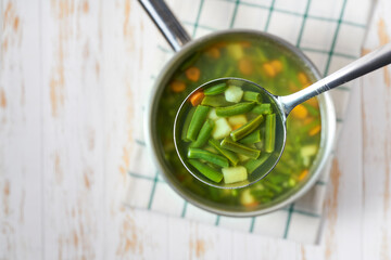 Green soup with potato, green bean and carrot , top view. Selective focus.