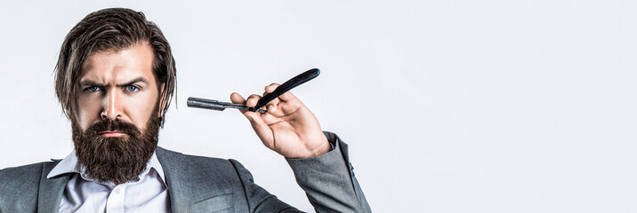 Man in barbershop. Handsome bearded hairdresser is holding a straight razor while barbershop. Straight razor, barbershop, beard. Vintage straight razor. Mens haircut