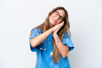Young surgeon doctor woman isolated on blue background making sleep gesture in dorable expression