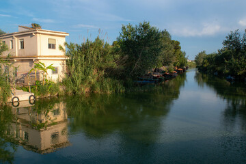 Fototapeta na wymiar Sunset in the famous lagoon of Valencia. Dock for traditional boats. Walks along the lagoon